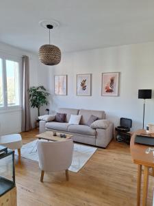a living room with a couch and a table at Appartement hyper centre, cathédrale, fibre in Lisieux