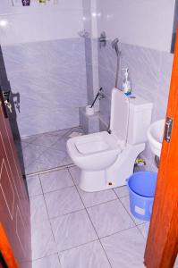 uma casa de banho com um WC branco e um chuveiro em Roma Stays - Classy Studio Apartment in Nyali ( Opp Shell Links Road) em Mombasa