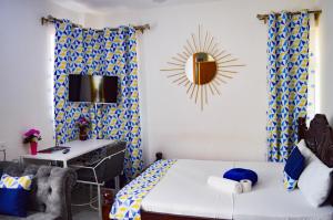 um quarto com uma cama e uma secretária em Roma Stays - Classy Studio Apartment in Nyali ( Opp Shell Links Road) em Mombasa