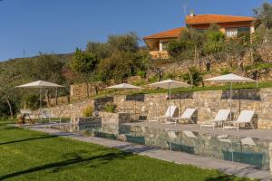 a pool with chairs and umbrellas and a house at Villa Chicchi - Sestri Levante in Sestri Levante