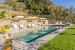 塞斯特里萊萬泰的住宿－Villa Chicchi - Sestri Levante，庭院内带椅子和遮阳伞的游泳池