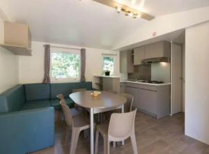 a kitchen and dining room with a table and chairs at Mobil Home 6 personnes 206 in Mens