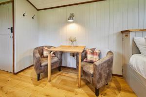 Zimmer mit einem Tisch, 2 Stühlen und einem Bett in der Unterkunft Host & Stay - Black Mountains Bespoke Breaks in Bronllys