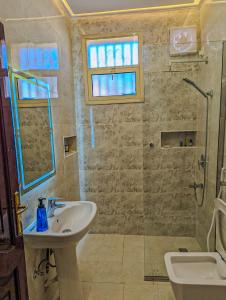 a bathroom with a sink and a shower at Madina Luxe Apartments - 7 minutes to Haram by Car - Mount Uhud Views - Free Parking - Kitchen in Al Madinah