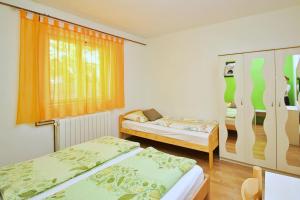 um quarto com duas camas e uma janela em Apartments Andelka G em Šilo