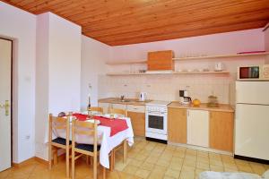 a kitchen with a table and chairs and a kitchen with a stove at Apartments Andelka G in Šilo