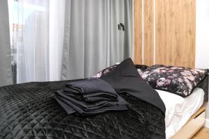 a bed with black sheets and pillows on it at Komfortowy Apartament w Warszawie, Bemowo, Lazurowa, blisko Metra in Warsaw