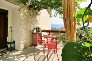 a red table and chairs on a patio with a view at Apartments Andelka G in Šilo
