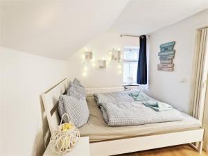 a bed in a room with white walls and a window at Urlaubsmagie - Ferienwohnung Turmfalke - Garten mit Terrasse & Saisonaler Pool - H6 in Sebnitz