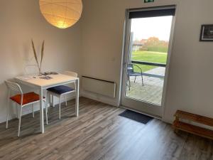 a room with a table and chairs and a sliding glass door at Kragenæshus in Torrig