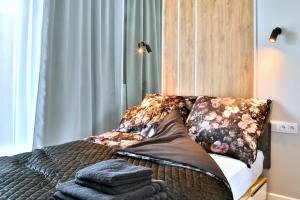 ein Bett mit Kissen darauf im Schlafzimmer in der Unterkunft Narwik Comfort Warszawa Bemowo in Warschau