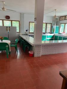 cocina con barra con sillas verdes y piscina en Cabaña Coveñas Los García, en Coveñas