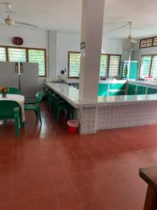 a kitchen with a counter with green chairs and a pool at Cabaña Coveñas Los García in Coveñas