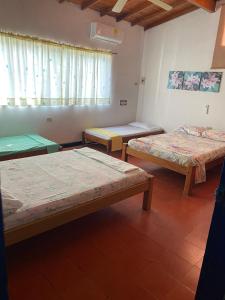eine Gruppe von 3 Betten in einem Zimmer in der Unterkunft Cabaña Coveñas Los García in Coveñas