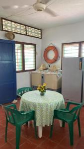 科韋尼亞斯的住宿－Cabaña Coveñas Los García，一间设有桌子、两把椅子和一张鲜花桌的房间
