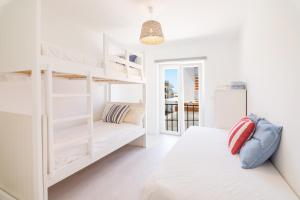 sypialnia z 2 łóżkami piętrowymi i kanapą w obiekcie Meggie Moo Beach House w mieście Praia da Areia Branca