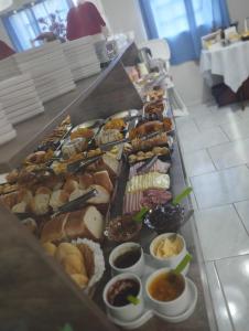 a buffet line with many different types of pastries at Pousada Águia da Serra Gramado 1 in Gramado