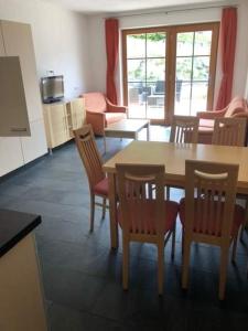a room with a table and chairs and a kitchen at Tobadill Apartments in Tobadill