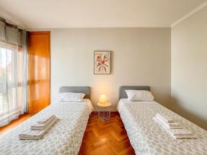 - deux lits assis l'un à côté de l'autre dans une pièce dans l'établissement Comfortable apartment in Viana do Castelo, à Viana do Castelo