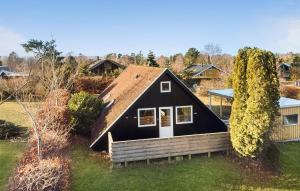 ein schwarzes Haus mit einem Dach auf einem Hof in der Unterkunft 3 Bedroom Beautiful Home In Vordingborg in Vordingborg