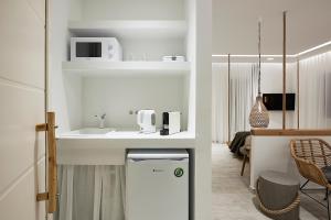 a kitchen with a sink and a white counter top at Nirome Luxury Suites in Adamantas