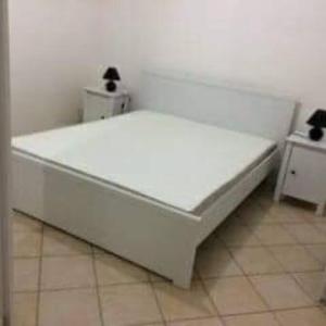 Cama blanca grande en habitación con suelo de baldosa en Villa de vacance en Sicile 