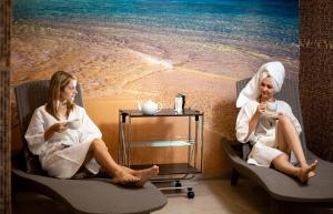 two women sitting in chairs with cups of coffee at Hotel Complex Olimp in Uman