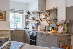 a kitchen with wooden shelves and a counter top at Quintessential Apartment, The Coach house in Blockley