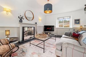 a living room with a couch and a table at Quintessential Apartment, The Coach house in Blockley