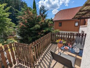 a patio with a wooden fence and a table and chairs at Urlaubsmagie - Ferienwohnung Turmfalke - Garten mit Terrasse & Saisonaler Pool - H6 in Sebnitz