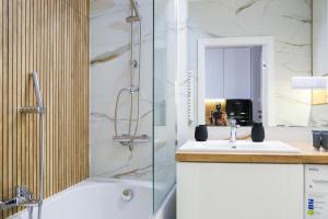 a bathroom with a shower and a sink and a tub at Narwik Comfort Warszawa Bemowo in Warsaw