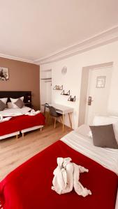 una camera d'albergo con due letti e un asciugamano sul letto di Jeff Hotel a Parigi