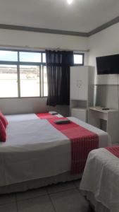 a bedroom with a large bed with a red blanket at HOTEL CYSNE in Sobral