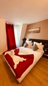 um quarto com uma cama grande e cortinas vermelhas em Jeff Hotel em Paris
