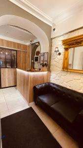 a living room with a black leather couch and a kitchen at Jeff Hotel in Paris