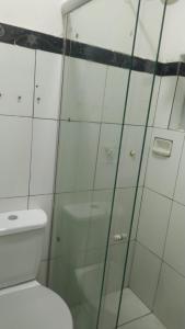 a bathroom with a toilet and a glass shower at HOTEL CYSNE in Sobral