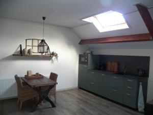 a kitchen with a table and a refrigerator and a window at Bij Leentjer geheel appartement 