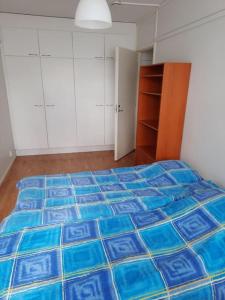 a bedroom with a bed with a blue comforter at Borrar in Espoo