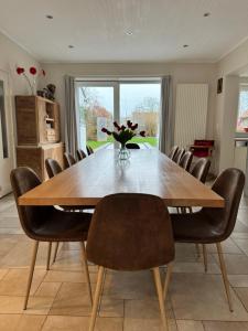 a dining room table with chairs and a vase of flowers at De Lanterfanters Vakantiehuis Jef in Nieuwpoort