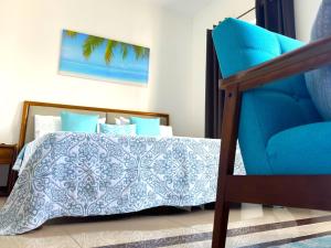 - une chambre avec un lit bleu et une chaise bleue dans l'établissement Residence Le Point Choisy, à Pointe aux Cannoniers