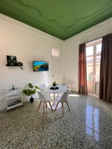 un soggiorno con tavolo e sedie bianchi di Valguarnera Suites & Apartments a Palermo