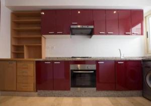 a kitchen with red cabinets and a stove at Superbe appartement à la corniche de Casablanca in Casablanca