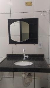a bathroom counter with a sink and a mirror at HOTEL CYSNE in Sobral