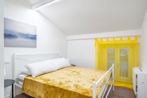 Cascina Conicchio - Metro Station - by Host4U في بريشيا: غرفة بيضاء بسرير وباب اصفر