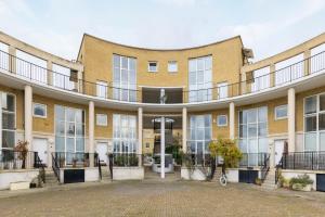 an exterior view of a large brick building with a courtyard at The Canada Water Apartments in London