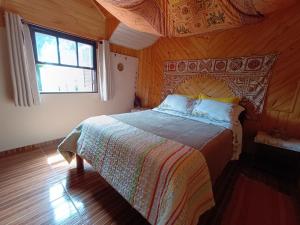 1 dormitorio con 1 cama con techo de madera en Casa Dell Angelo Apartamentos, en Visconde De Maua
