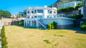 Una gran casa blanca con un patio de césped. en Villa Valentino1, en Karabağ