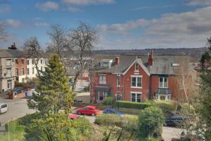 un groupe de maisons dans une ville avec des voitures garées dans l'établissement Convenient 2-Bed Flat, Great for Workers & Small Groups - FREE Parking & Netflix, à Sheffield