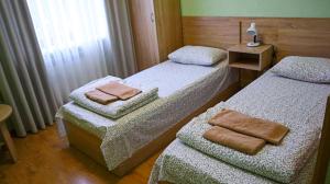 ein Zimmer mit 2 Betten und Handtüchern darauf in der Unterkunft Каприз in Kamjanez-Podilskyj