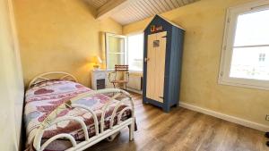 Habitación pequeña con cama y ventana en Charmante villa face à la mer !, en La Flotte